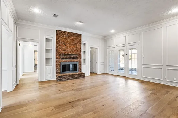a view of an empty room with a fireplace and a window