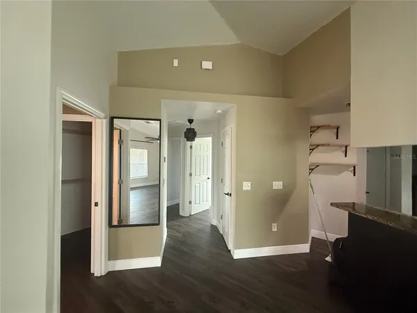 a kitchen with a refrigerator and wooden floor