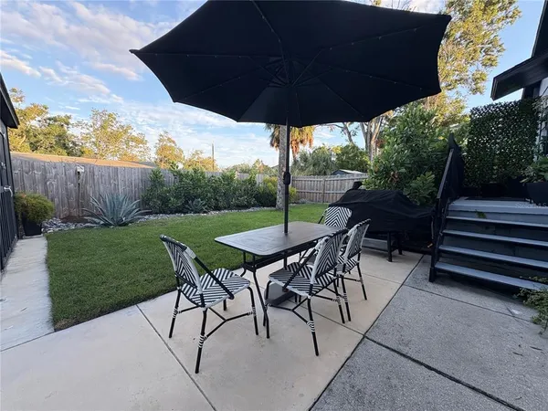 a view of a backyard with table and chairs under an umbrella