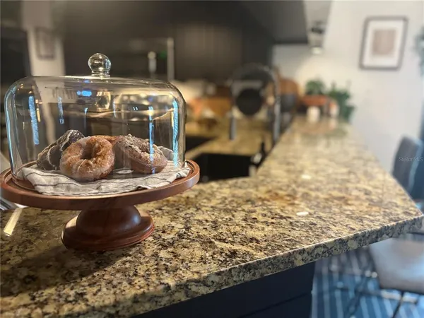 a room with lots of white furniture and a chandelier