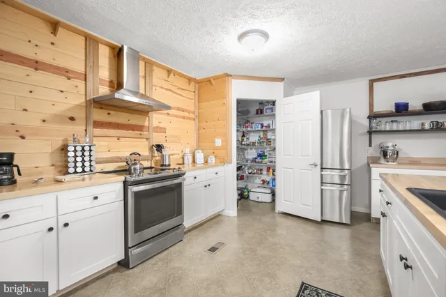 a kitchen with stainless steel appliances a refrigerator sink and cabinets