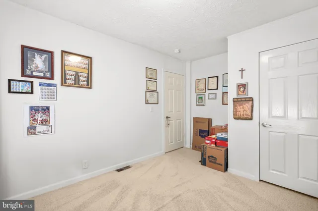 a view of a bedroom with baby bed toys and paintings on the wall