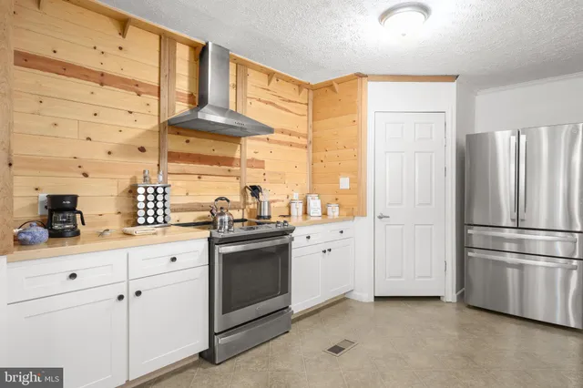 a kitchen with stainless steel appliances a stove a sink and a refrigerator