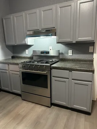 a kitchen with granite countertop white cabinets and white appliances