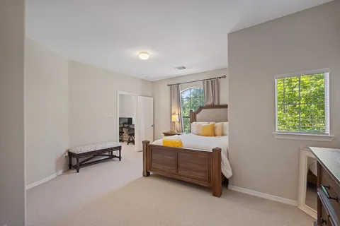 a bed sitting in a bedroom next to a window