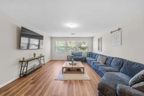 a living room with furniture and wooden floor