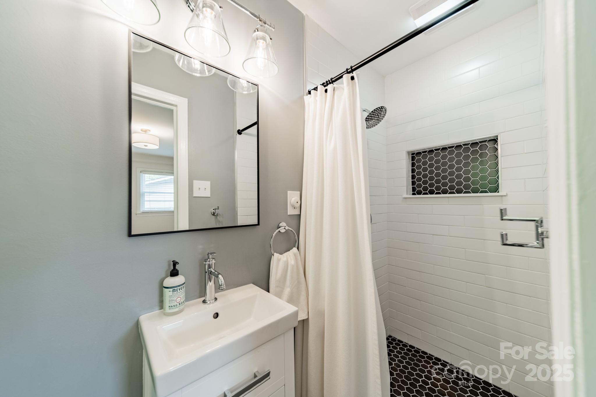 6339 Montpelier Road Charlotte, NC 28210 - Photo 22 of 35 a bathroom with a sink a mirror and shower