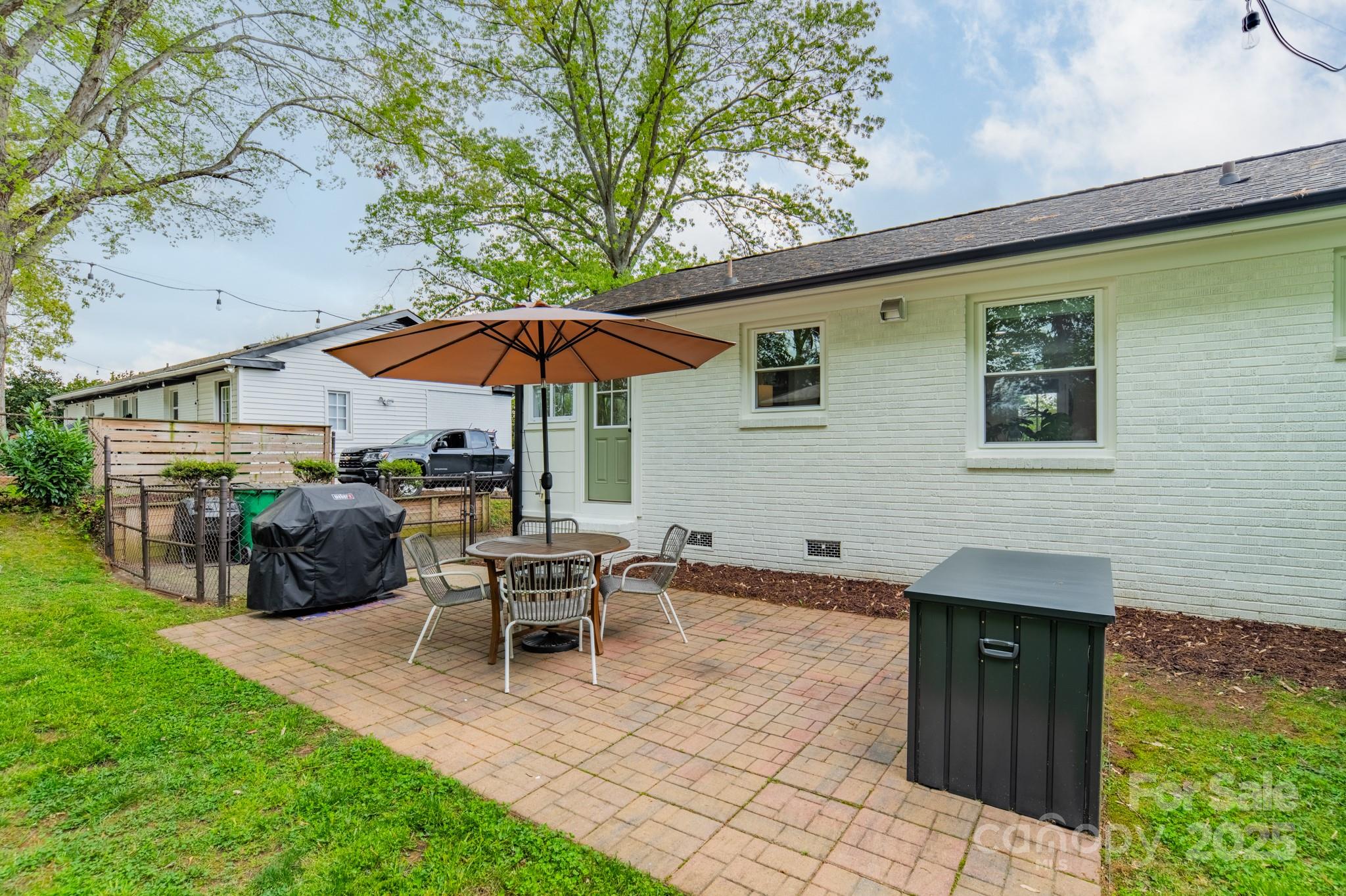 6339 Montpelier Road Charlotte, NC 28210 - Photo 23 of 35 a patio with a table and chairs under an umbrella