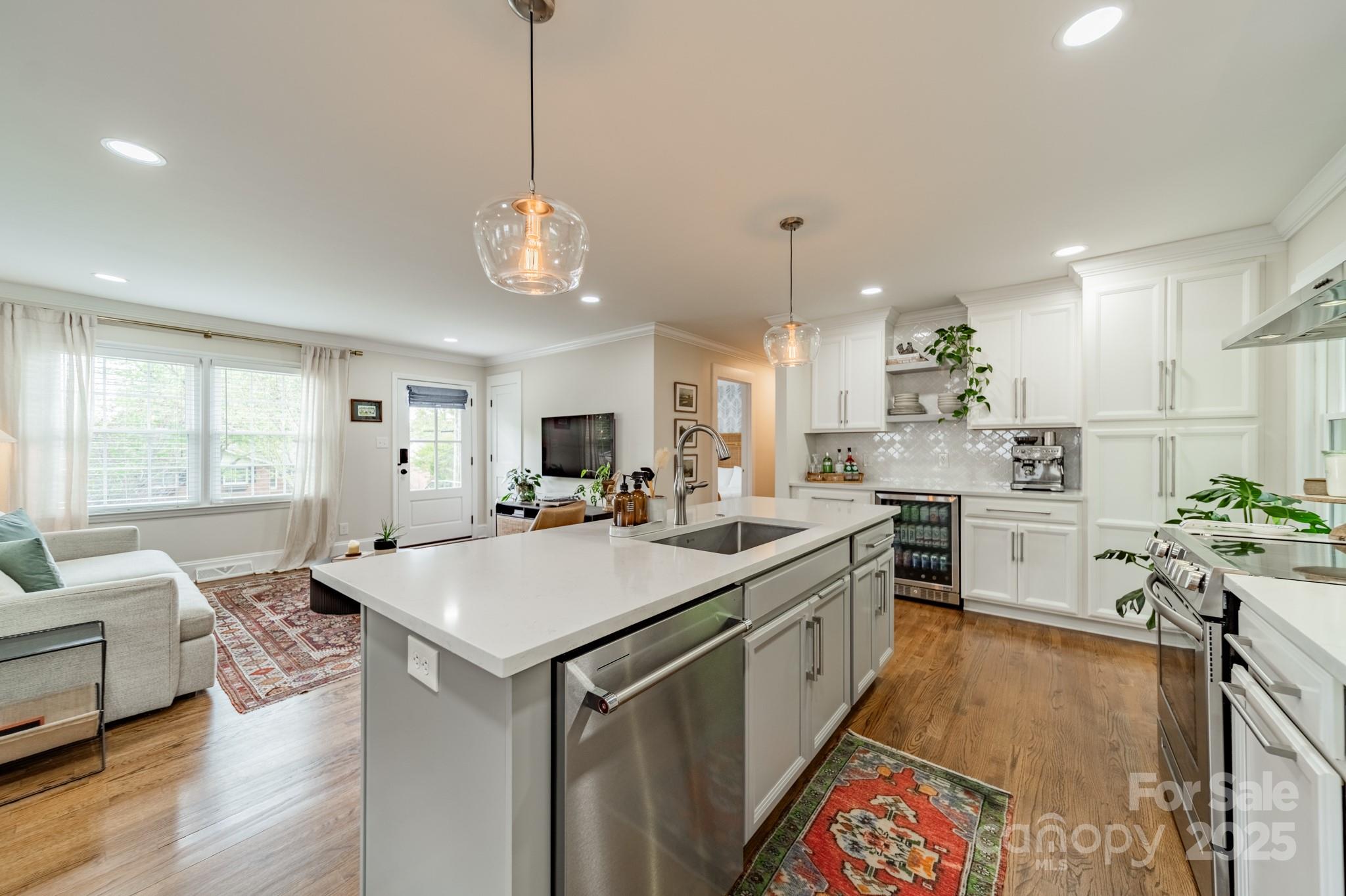 6339 Montpelier Road Charlotte, NC 28210 - Photo 10 of 35 a large kitchen with kitchen island a stove a sink a dining table and chairs with wooden floor