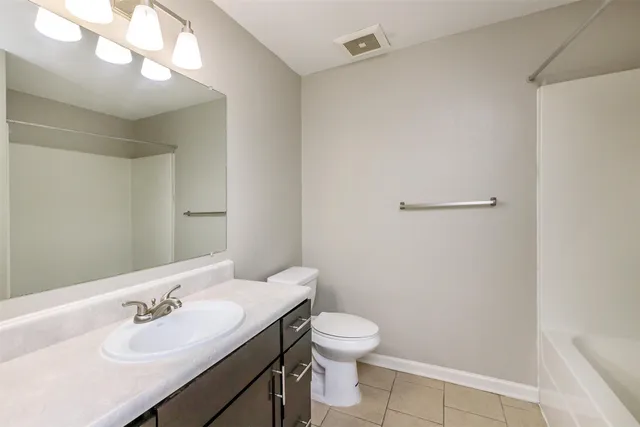 a bathroom with a sink mirror vanity and toilet
