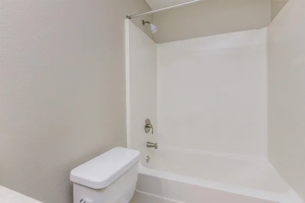 a white toilet and tub next to a shower