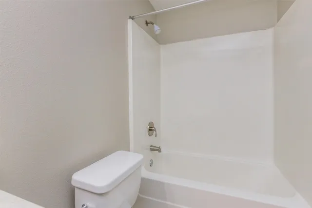 a white toilet and tub next to a shower