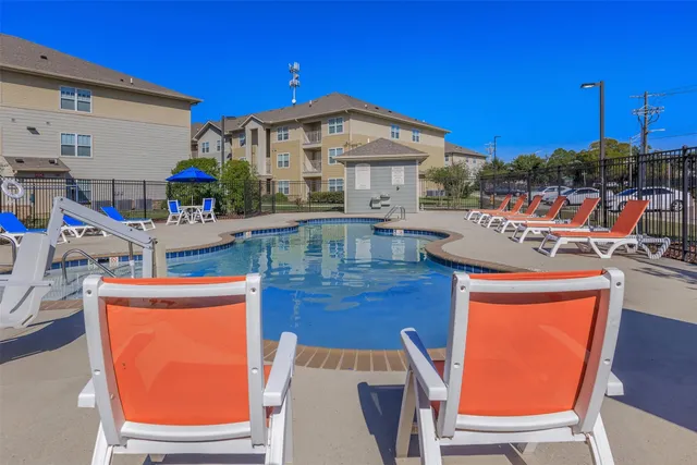 a view of a house with pool and chairs