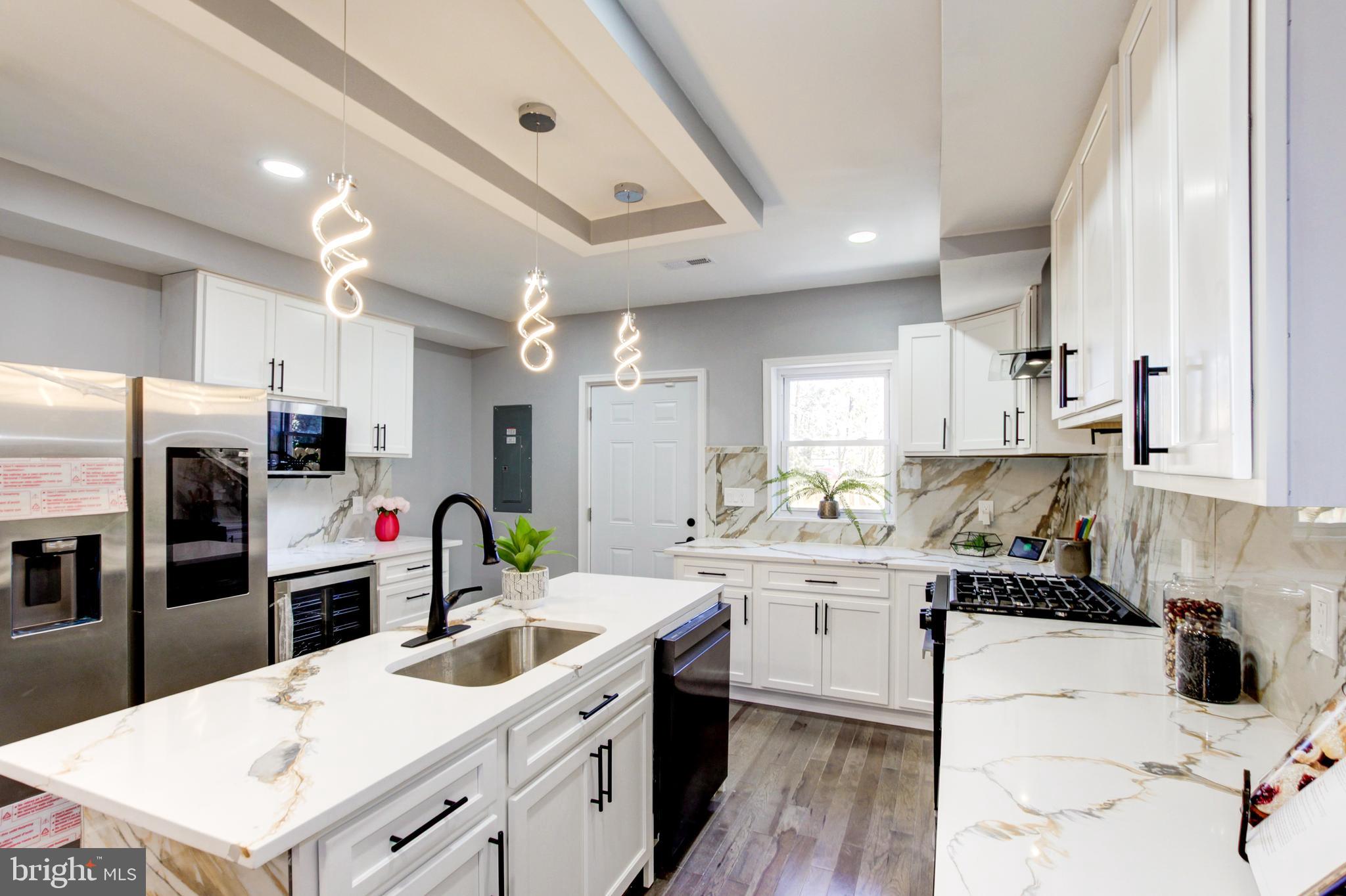 a kitchen that has a lot of cabinets a sink and appliances in it