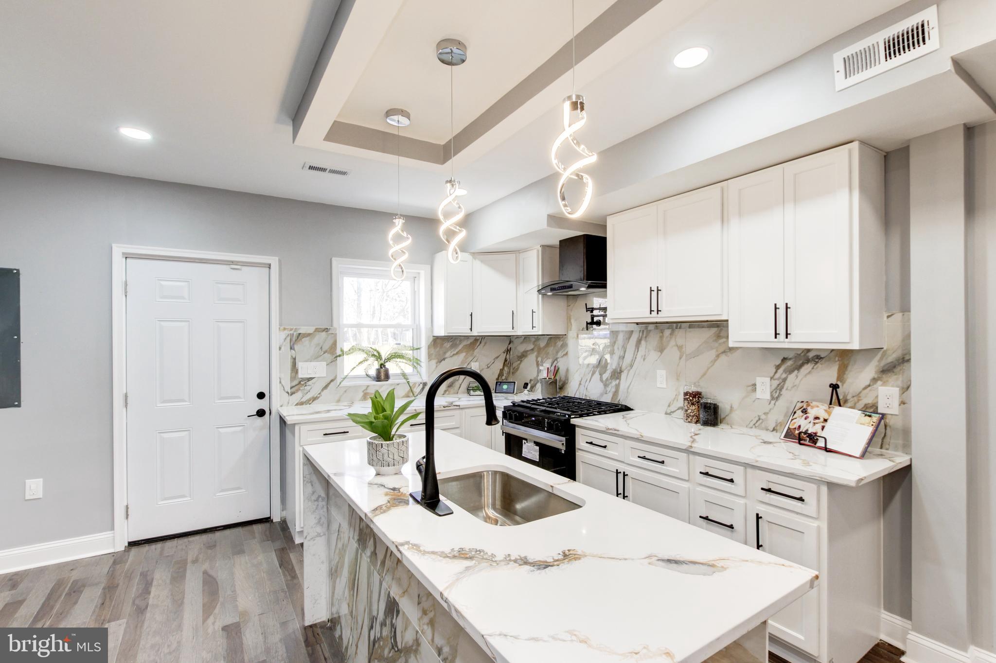 1613 Aisquith Street Baltimore, MD 21202 - Photo 15 of 46 a kitchen with a sink a stove and cabinets