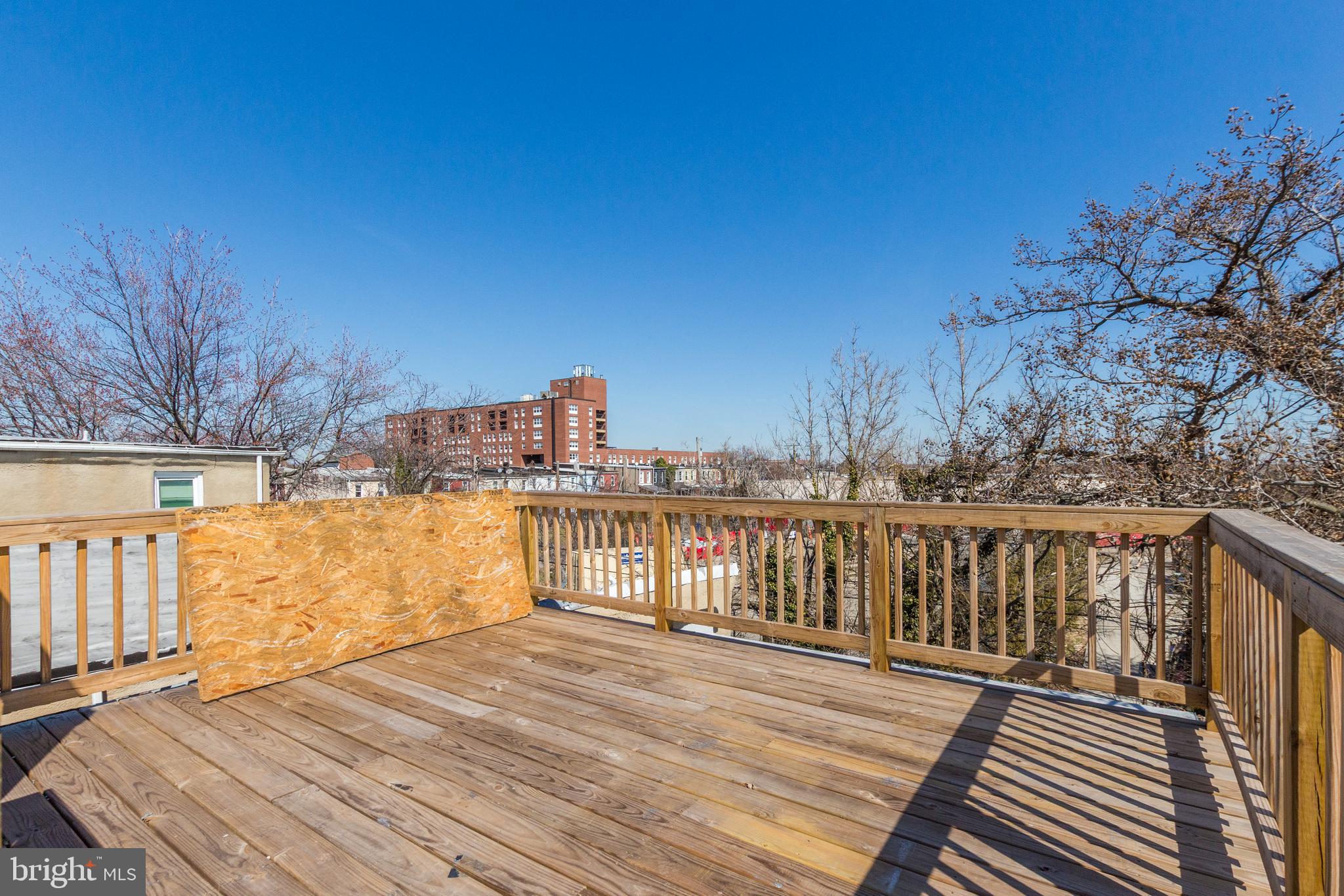 1613 Aisquith Street Baltimore, MD 21202 - Photo 32 of 46 a view of balcony with wooden floor and fence and trees