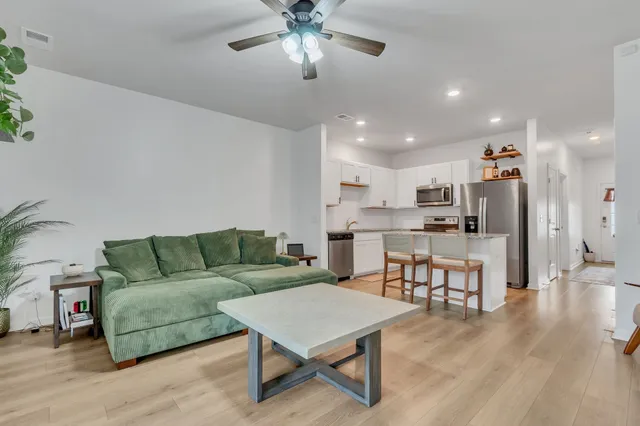 a living room with furniture and kitchen view