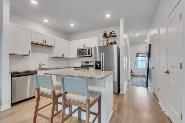 a kitchen with stainless steel appliances granite countertop a refrigerator and a stove top oven