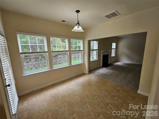 a view of an empty room with a fireplace and a window