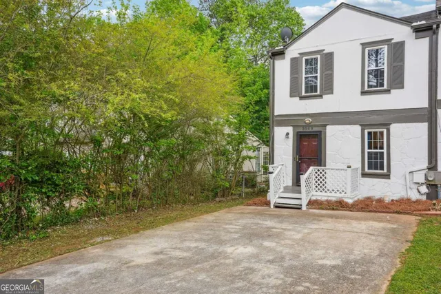 a view of a house with backyard and sitting area