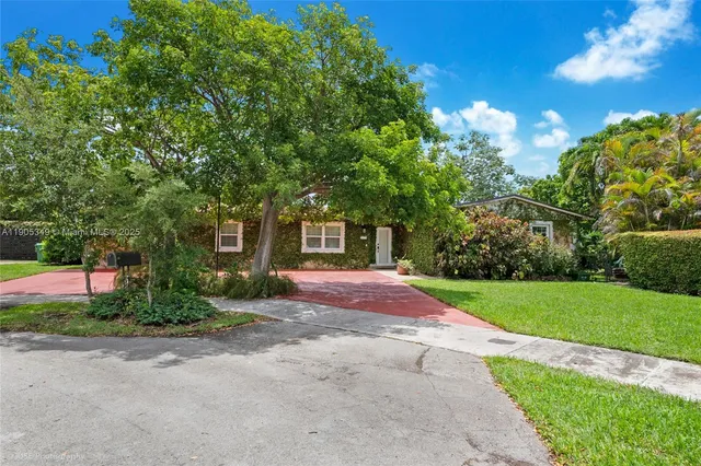 a front view of a house with yard and green space