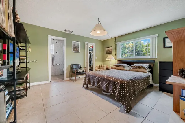 a bedroom with a bed a bookshelf a desk and chair