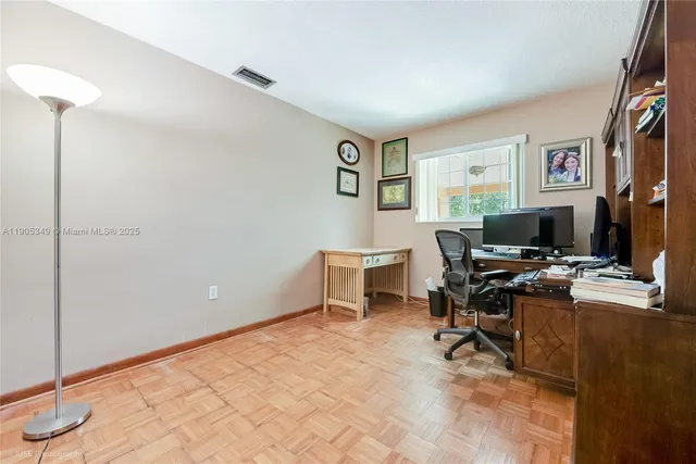 a view of a workspace with furniture and a window