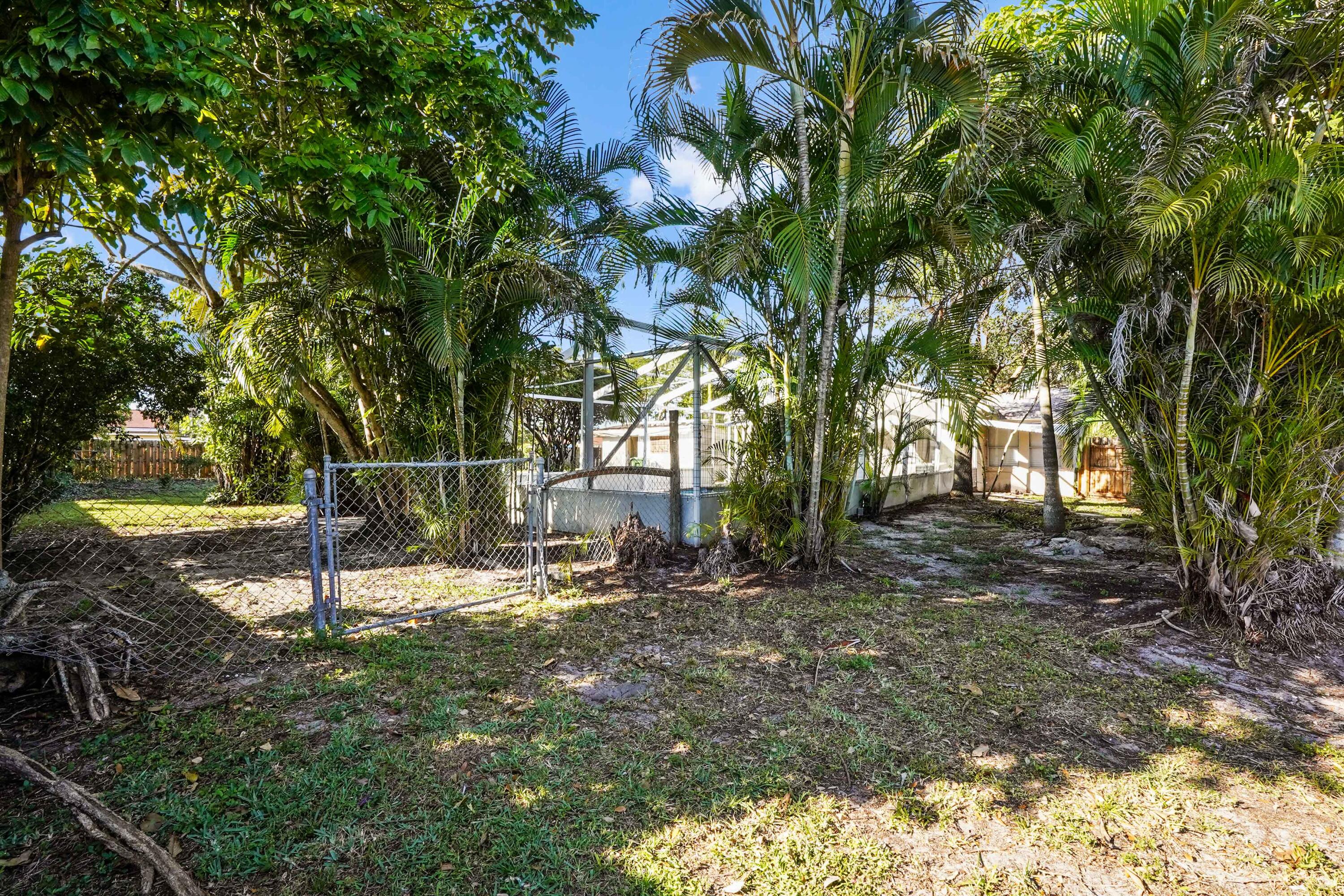 3858 Lakewood Road Palm Springs, FL 33461 - Photo 23 of 40 a backyard of a house with table and chairs