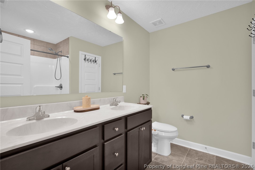 351 Sandy Grove Road Parkton, NC 28371 - Photo 21 of 30 a bathroom with a double vanity sink toilet and mirror