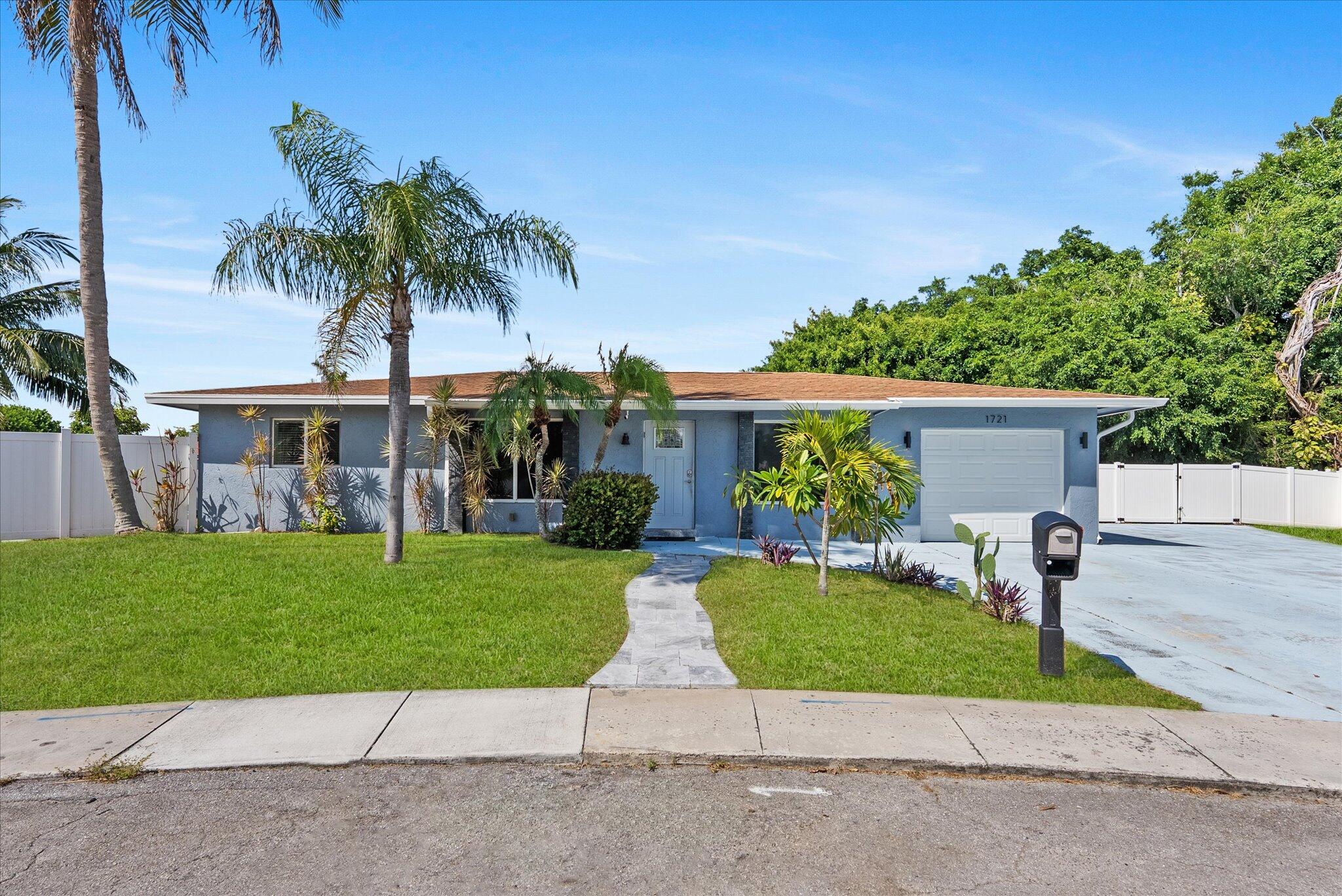 1721 Southwest 10th Street Boca Raton, FL 33486 - Photo 1 of 34 a front view of house with yard and green space