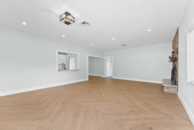 an empty room with windows and ceiling fan