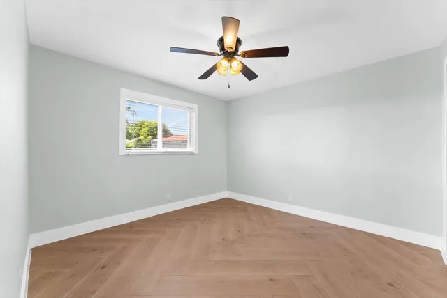 an empty room with closet and fan