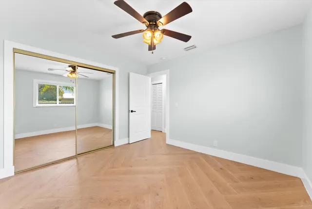 a bathroom with a granite countertop sink a toilet a mirror and shower