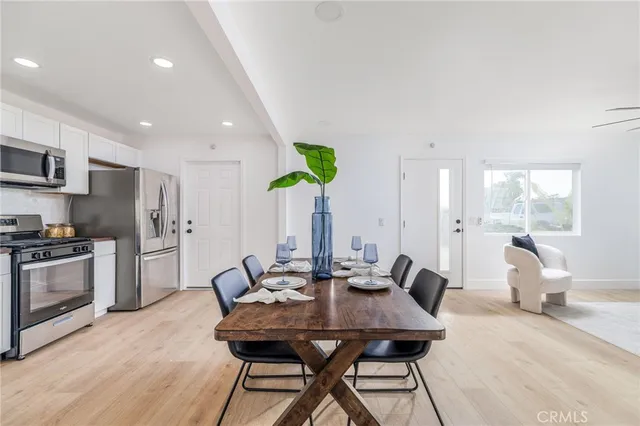 a kitchen with stainless steel appliances kitchen island granite countertop a refrigerator a stove a sink dishwasher with a dining table and chairs