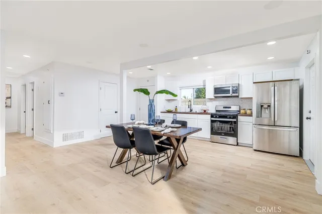 a kitchen with a table chairs refrigerator and microwave