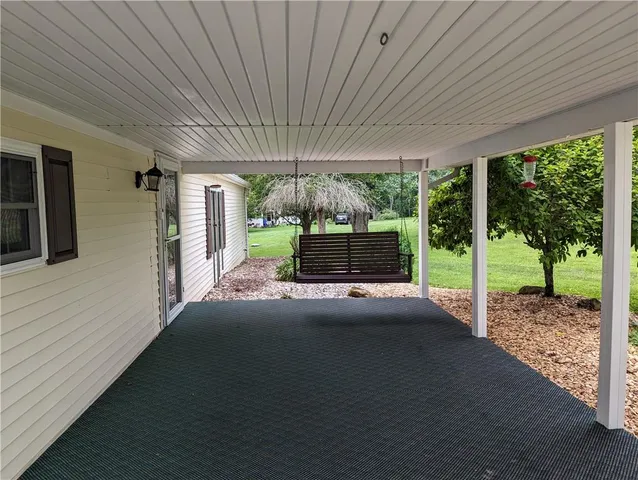 a view of a porch with furniture and garden