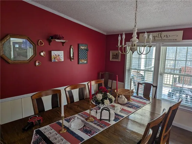 a view of a dining room with furniture a chandelier and wooden floor