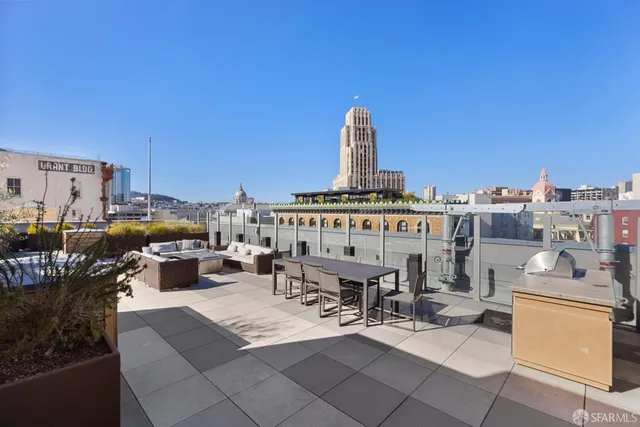 a view of roof deck with table and chairs