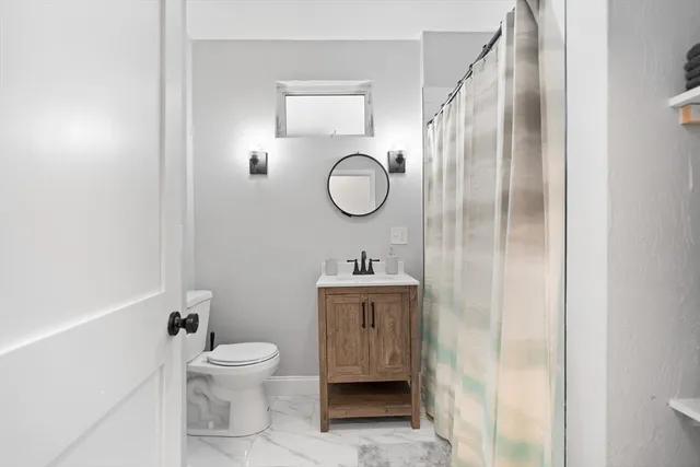 a bathroom with a toilet sink and mirror