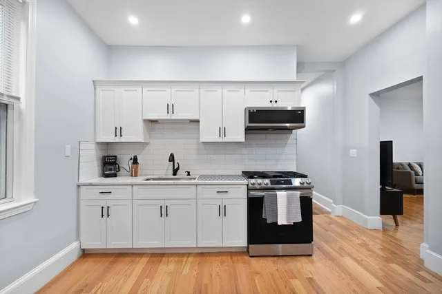 a kitchen with a stove top oven and cabinets
