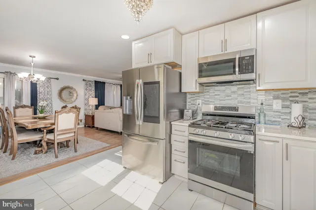 a kitchen with stainless steel appliances granite countertop a stove refrigerator and cabinets