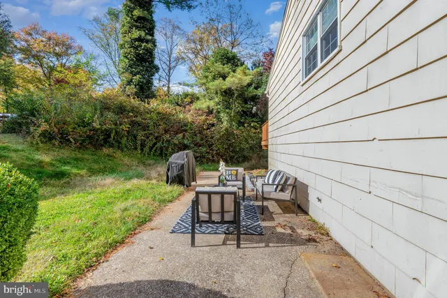 a view of a chair and table in backyard of the house