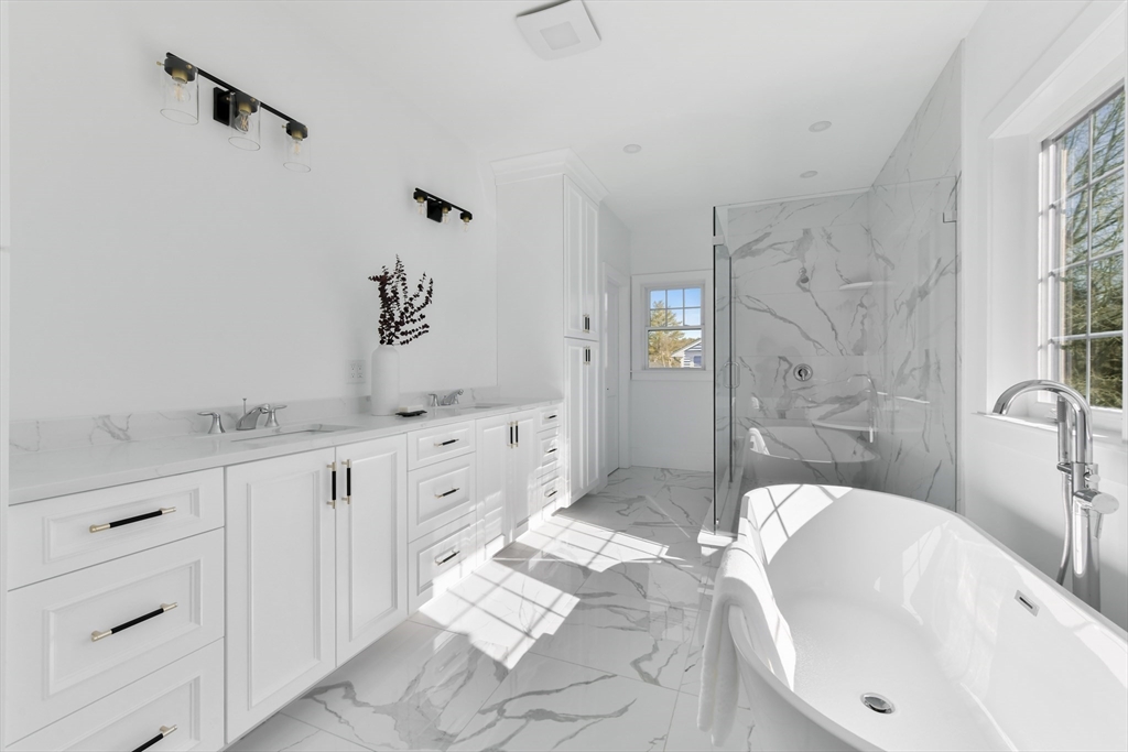 62 Brewster Drive Needham, MA 02492 - Photo 24 of 42 a spacious bathroom with double vanity sink a mirror a bathtub and shower