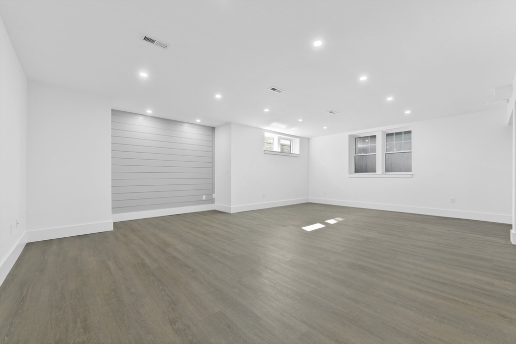 62 Brewster Drive Needham, MA 02492 - Photo 35 of 42 a view of an empty room with wooden floor and a window