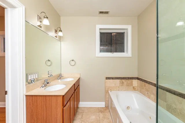 a bathroom with a tub sink and mirror