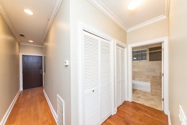a view of a hallway with a bedroom and wooden floor