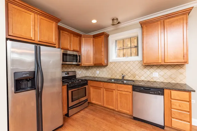 a kitchen with stainless steel appliances granite countertop a refrigerator and a stove top oven