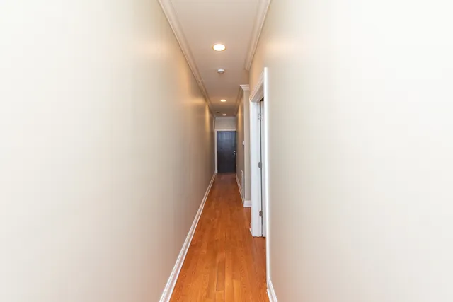 a view of a hallway with wooden floor
