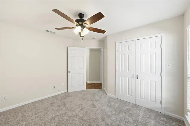 an empty room with a ceiling fan and a window
