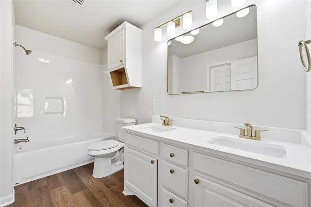 a bathroom with a toilet a sink a mirror and vanity